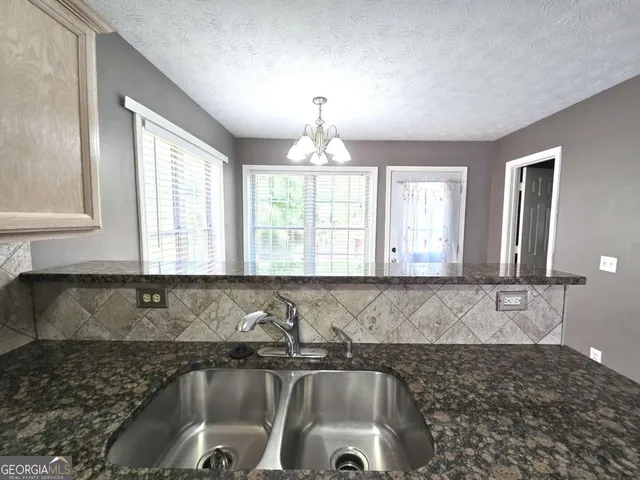 a view of a kitchen with a sink and chandelier
