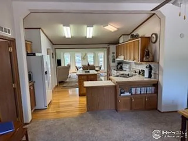 a kitchen with stainless steel appliances granite countertop a refrigerator a sink and a stove