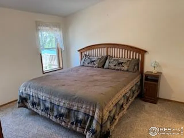 a large bed sitting in a bedroom next to a window