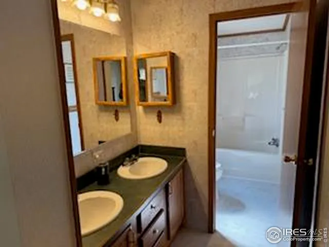 a bathroom with a granite countertop sink toilet a mirror and shower