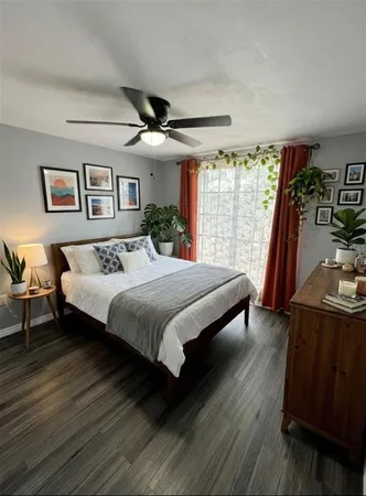 a spacious bedroom with a bed a couch and large window