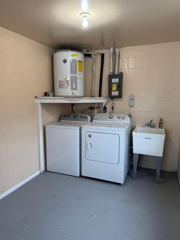 4025 Grayton Drive New Port Richey, FL 34652 - Photo 24 of 33 a utility room with a sink wooden cabinet washer and dryer