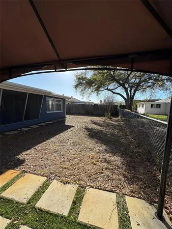 a view of a house with backyard and sitting area