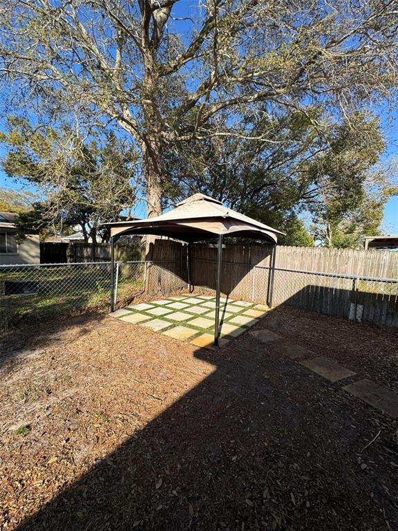 4025 Grayton Drive New Port Richey, FL 34652 - Photo 32 of 33 a view of a yard with table and chairs under an umbrella