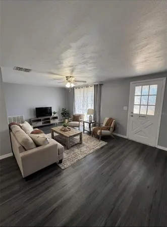 a living room with furniture and wooden floor