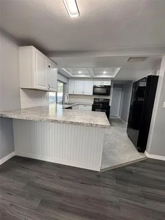 a view of kitchen with stainless steel appliances granite countertop a stove a refrigerator a sink and a oven