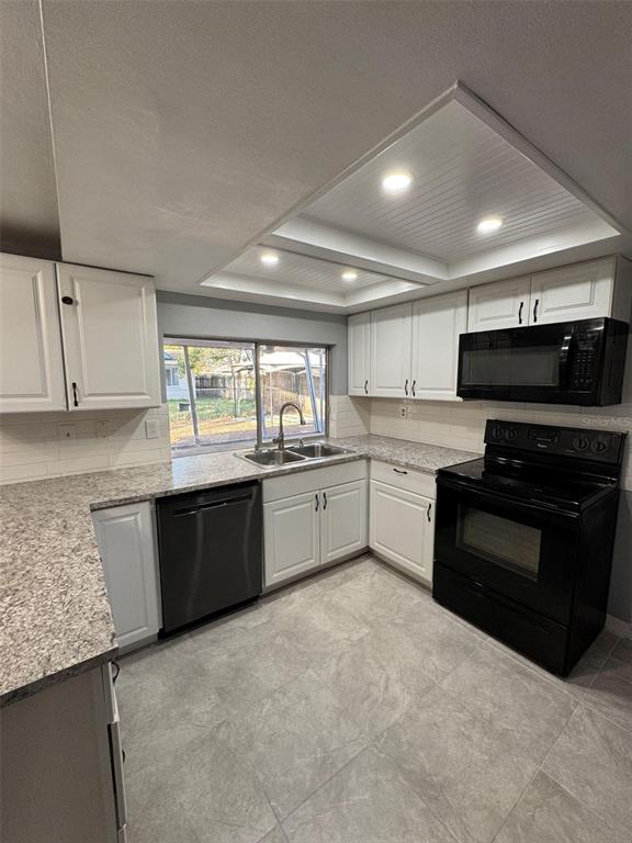 4025 Grayton Drive New Port Richey, FL 34652 - Photo 8 of 33 a large white kitchen with granite countertop a stove top oven a sink dishwasher and a refrigerator with wooden cabinets