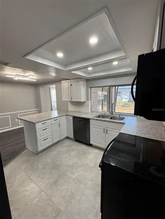 a large kitchen with stainless steel appliances a large counter top a stove and a refrigerator