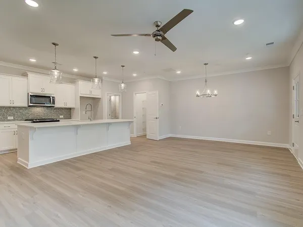 a view of kitchen with kitchen island stainless steel appliances refrigerator stove microwave and cabinets
