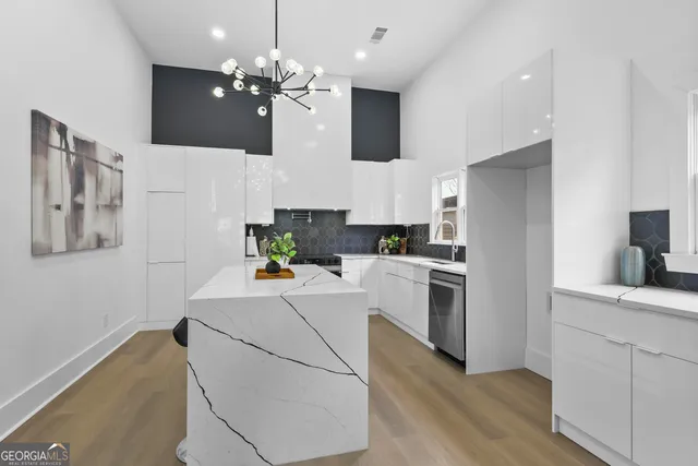 a kitchen with stainless steel appliances kitchen island granite countertop a stove a sink and a refrigerator