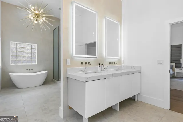 a bathroom with a bathtub a sink and a large mirror