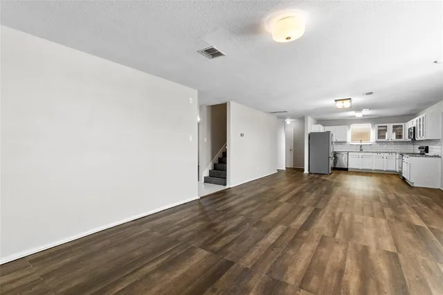 a kitchen with granite countertop a refrigerator and a sink