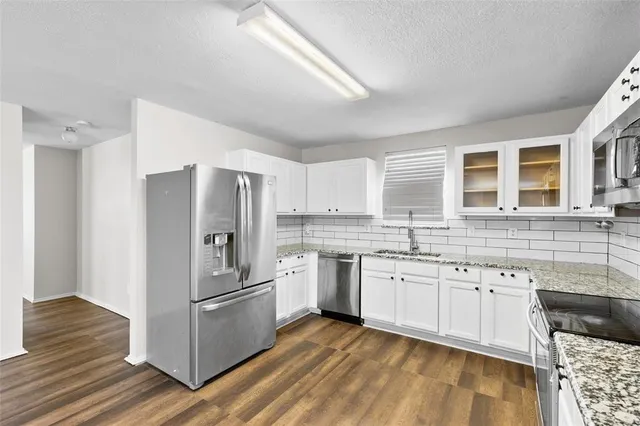 a kitchen with stainless steel appliances granite countertop a stove and a sink