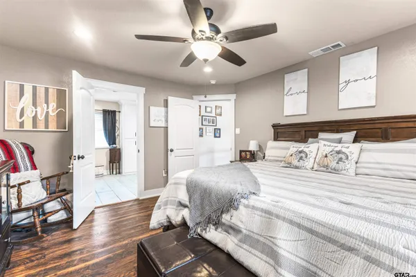 a spacious bedroom with a bed and wooden floor