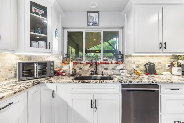 a kitchen with granite countertop a sink and a stove