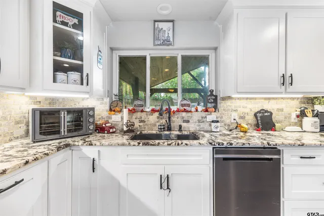 a kitchen with granite countertop a sink and a stove