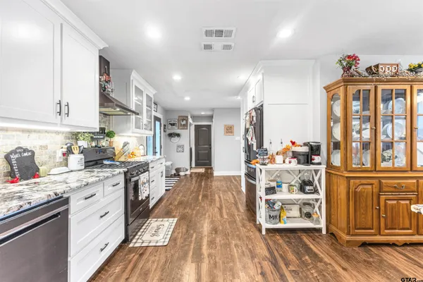 a kitchen with stainless steel appliances sink stove top oven and cabinets