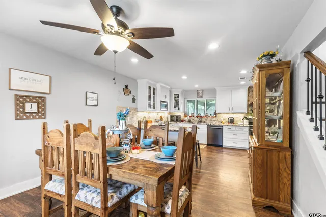 a view of a dining room and livingroom with furniture wooden floor a rug a fireplace