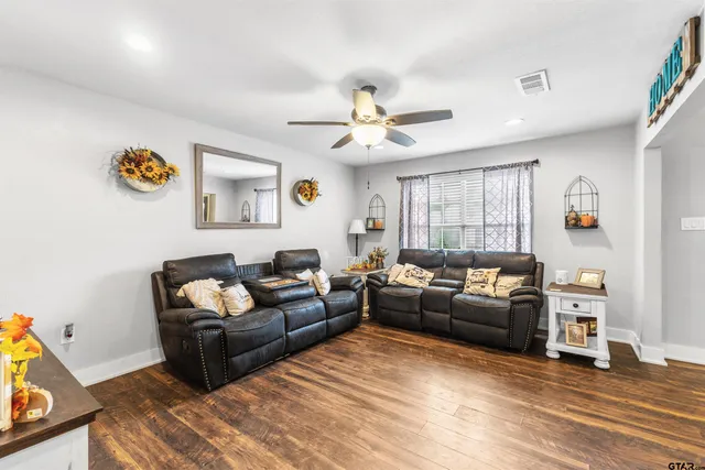 a living room with furniture and a wooden floor