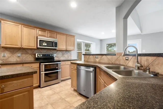 a kitchen with stainless steel appliances granite countertop a sink stove and microwave
