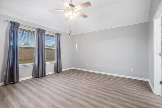 a view of an empty room with wooden floor