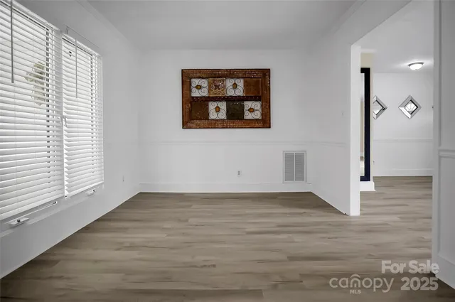 a view of a hallway with wooden floor and a large window