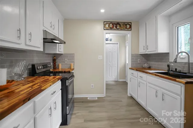 a kitchen with granite countertop white cabinets and white appliances