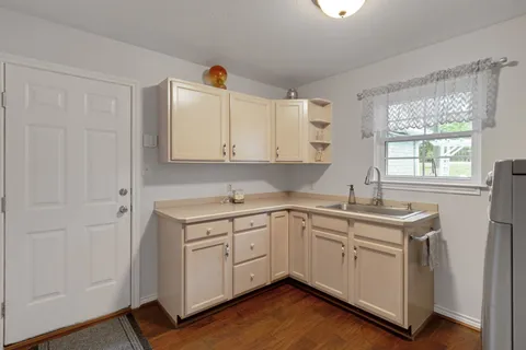 a kitchen with stainless steel appliances granite countertop a sink and cabinets with wooden floor