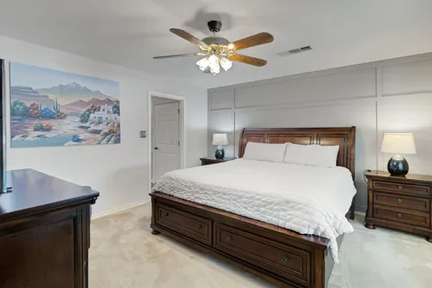 a bedroom with a bed and a painting on the wall