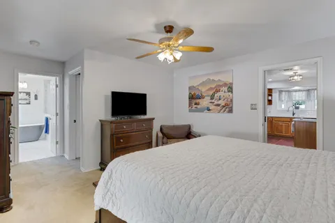a bedroom with a bed and a flat tv screen on dresser