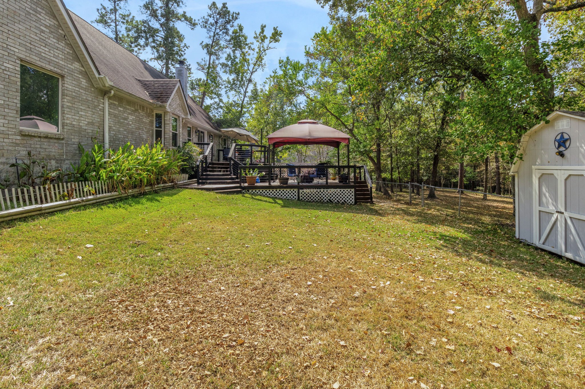 80 Lake Grove Drive Coldspring, TX 77331 - Photo 39 of 50 a view of a swimming pool with a table and chairs under an umbrella