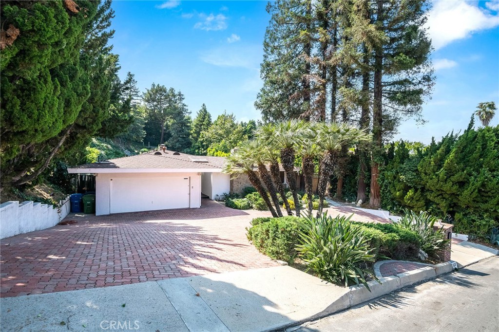 16258 Bertella Drive Encino, CA 91436 - Photo 2 of 45 a view of a white house with a yard and potted plants