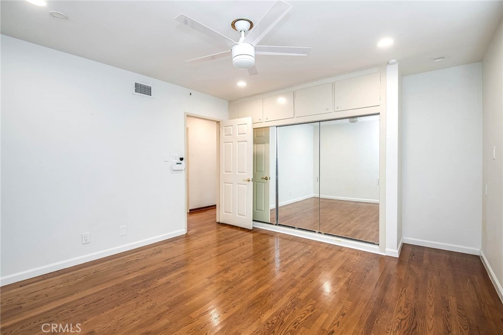 16258 Bertella Drive Encino, CA 91436 - Photo 22 of 45 an empty room with wooden floor and a ceiling fan