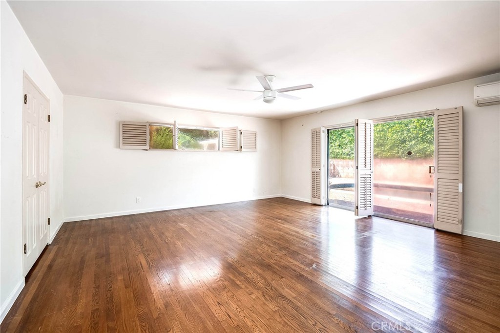 16258 Bertella Drive Encino, CA 91436 - Photo 26 of 45 an empty room with wooden floor and windows