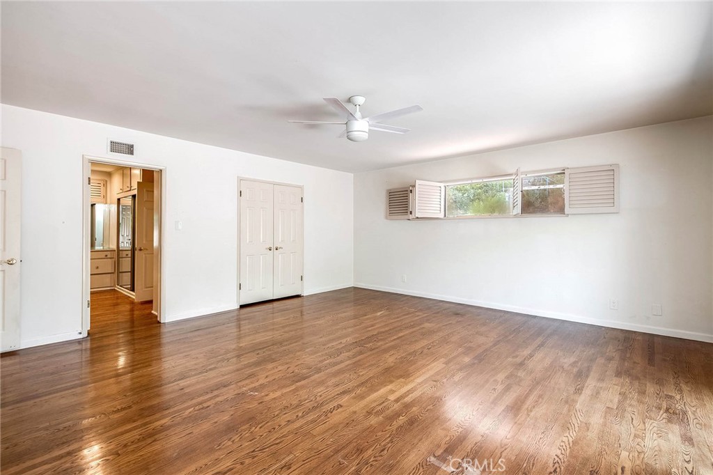 16258 Bertella Drive Encino, CA 91436 - Photo 27 of 45 an empty room with wooden floor ceiling fan and windows