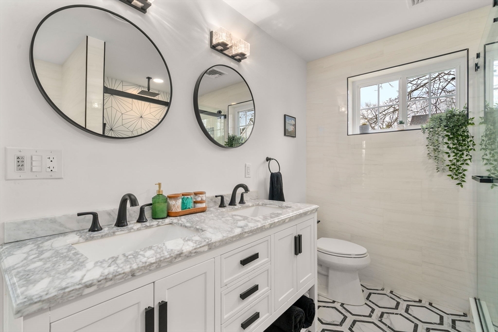 6 Ash Street Natick, MA 01760 - Photo 21 of 39 a bathroom with a granite countertop toilet a sink and a mirror
