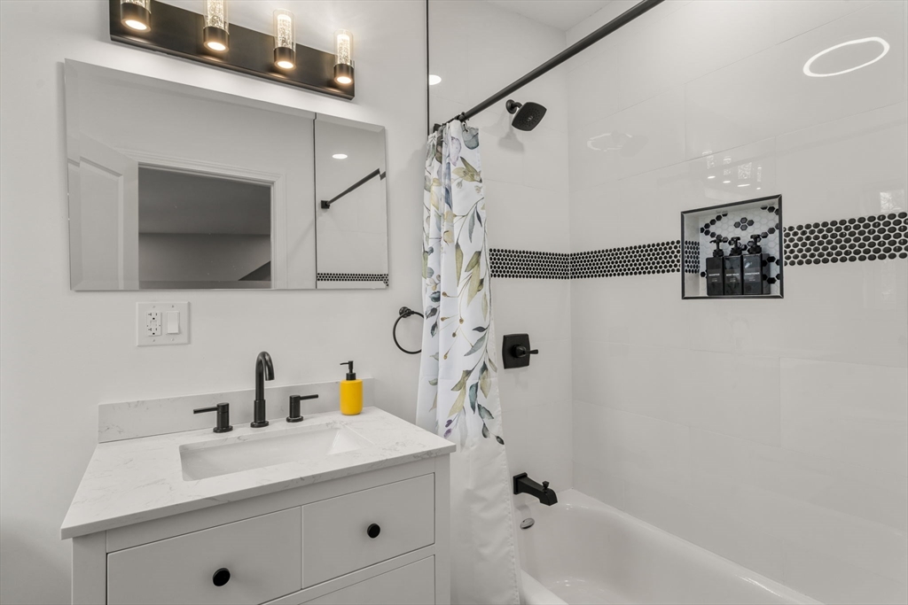 6 Ash Street Natick, MA 01760 - Photo 30 of 39 a bathroom with a sink a mirror and shower