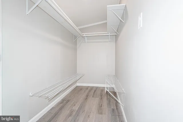 a view of walk in closet with empty racks