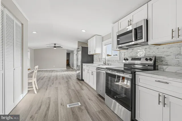 a kitchen with stainless steel appliances a stove top oven a sink dishwasher and a refrigerator