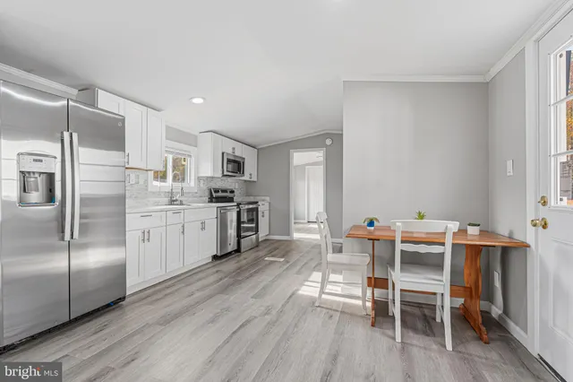 a kitchen with granite countertop cabinets a counter space dining table and stainless steel appliances