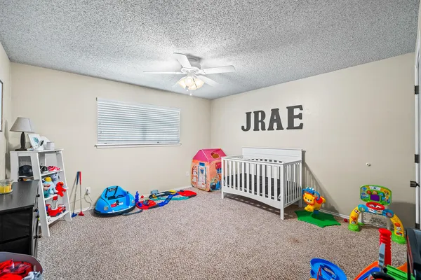 a children room with toys and a fan