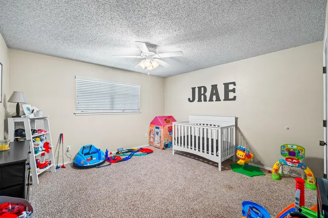 a children room with toys and a fan