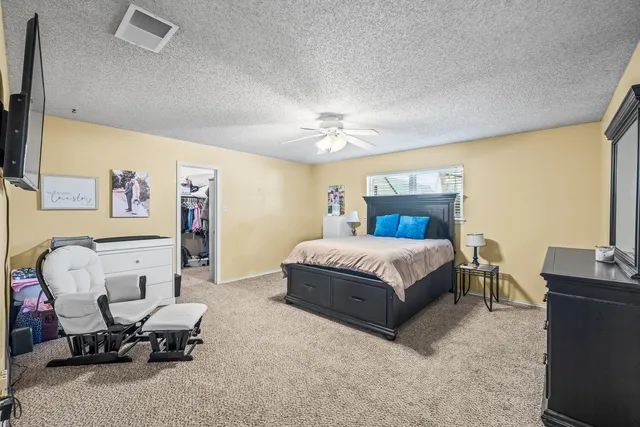 a spacious bedroom with a bed and a chair