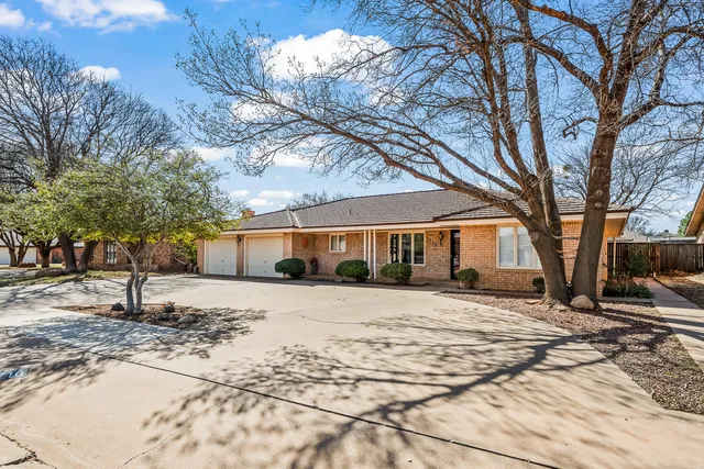 a front view of a house with a yard covered in snow