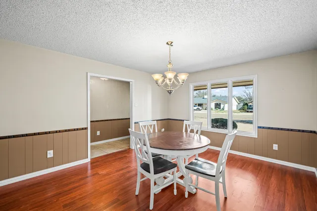 a view of a dining room with furniture a chandelier and wooden floor