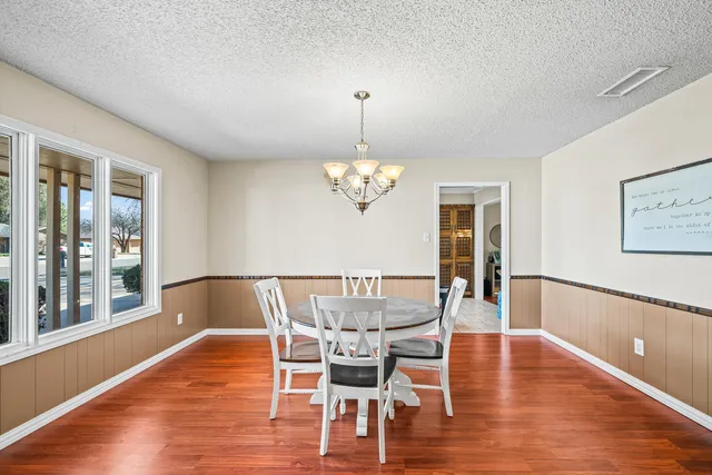 a view of a dining room with furniture wooden floor and chandelier