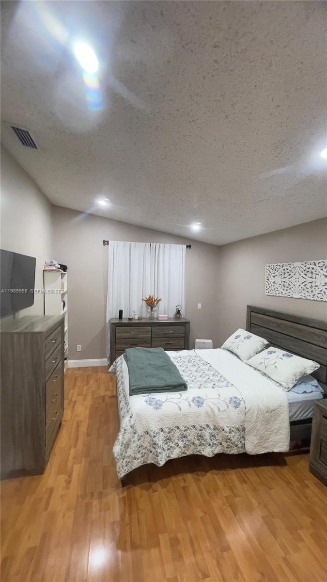 14252 Southwest 175th Terrace Miami, FL 33177 - Photo 15 of 39 a spacious bedroom with a bed and a flat screen tv