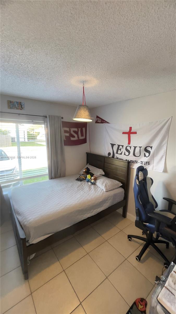 14252 Southwest 175th Terrace Miami, FL 33177 - Photo 19 of 39 a bedroom with a bed and a chandelier