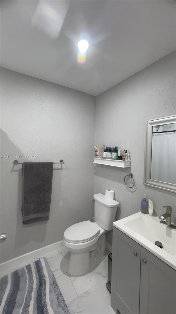 14252 Southwest 175th Terrace Miami, FL 33177 - Photo 33 of 39 a bathroom with a toilet a sink and a mirror
