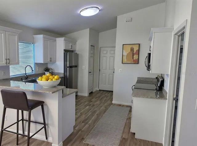 a kitchen with stainless steel appliances granite countertop a refrigerator and a stove top oven